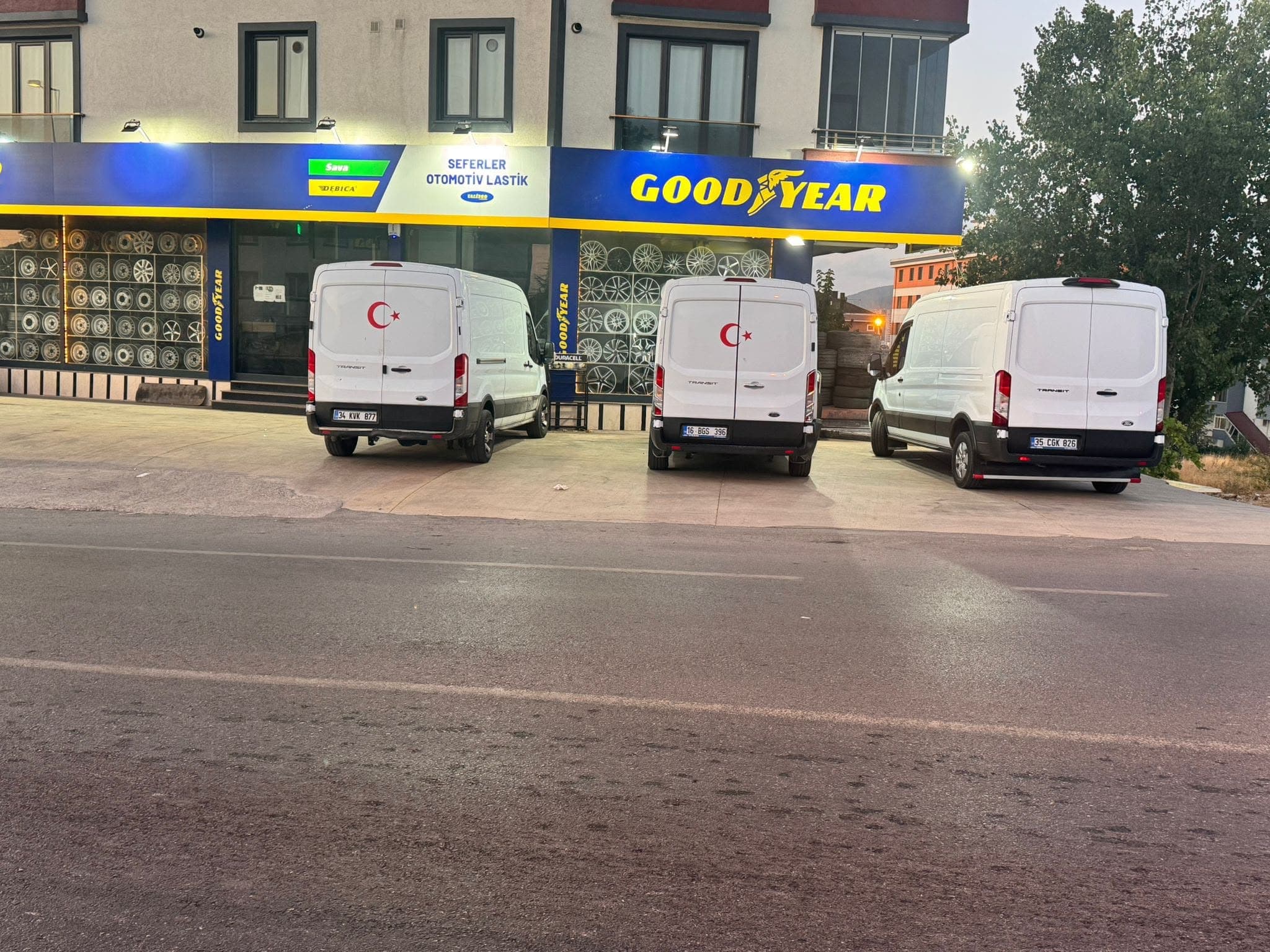 Yan yana park edilmiş üç beyaz mobil servis aracı