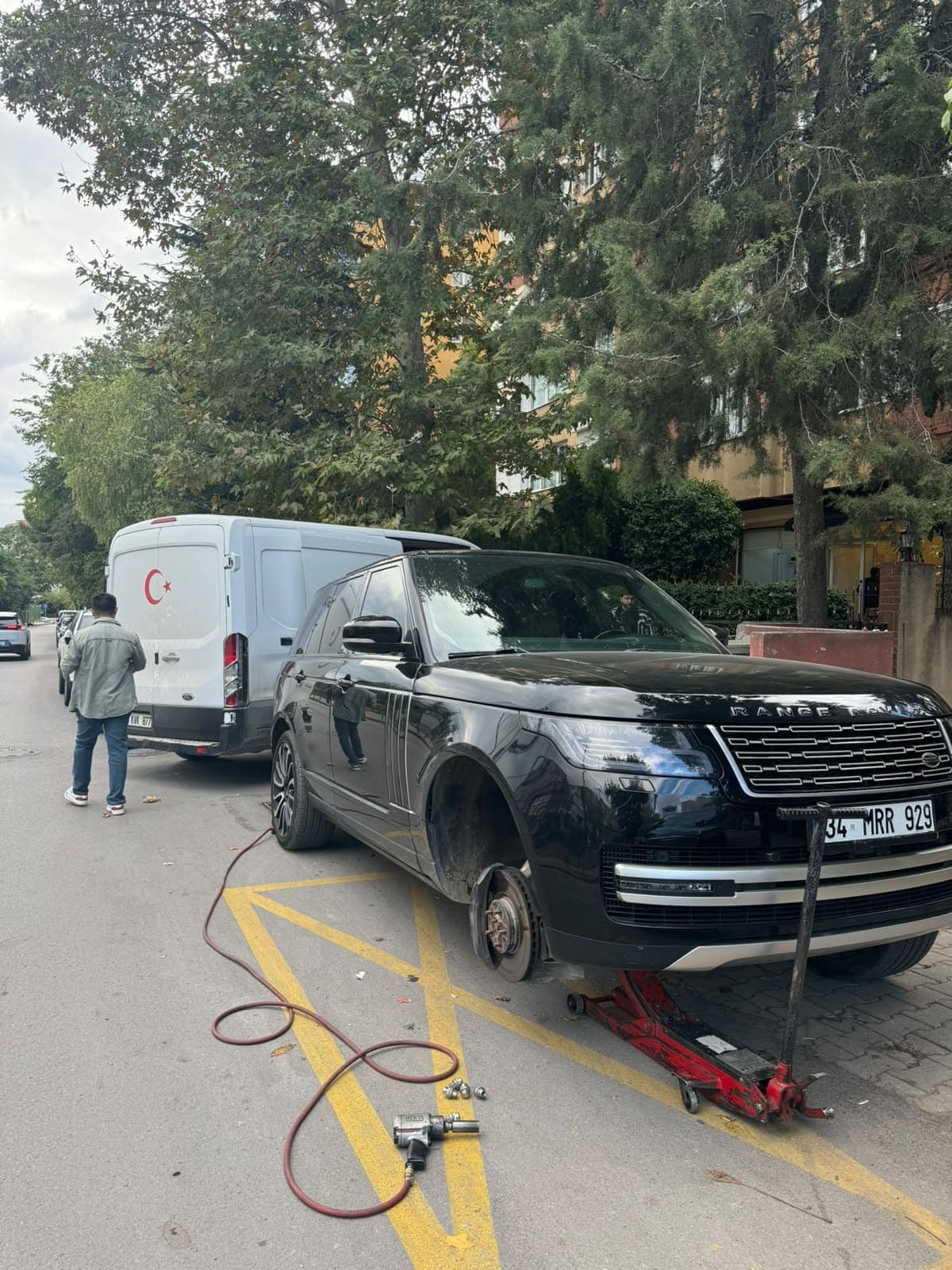 Yol kenarında ön tekerleği sökülmüş SUV araç, kriko ve servis ekipmanı